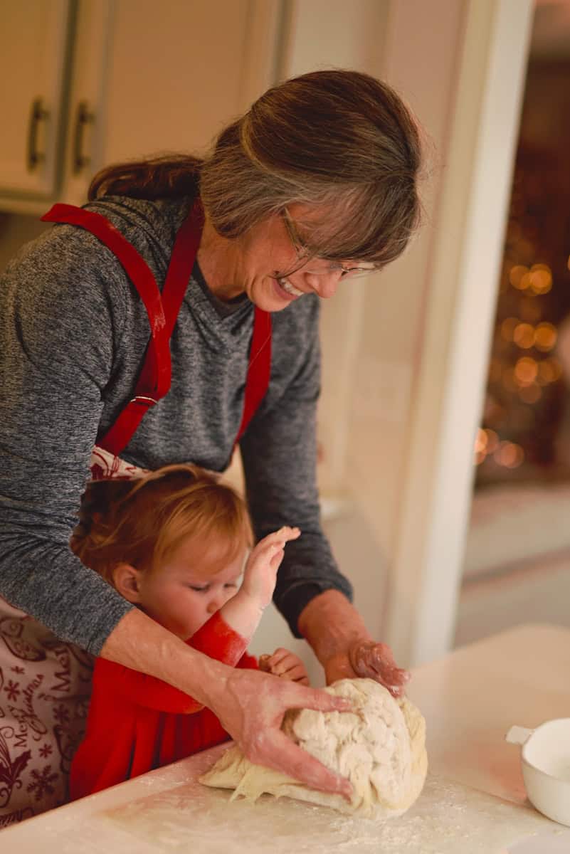 grandma helping granddaughter make dough